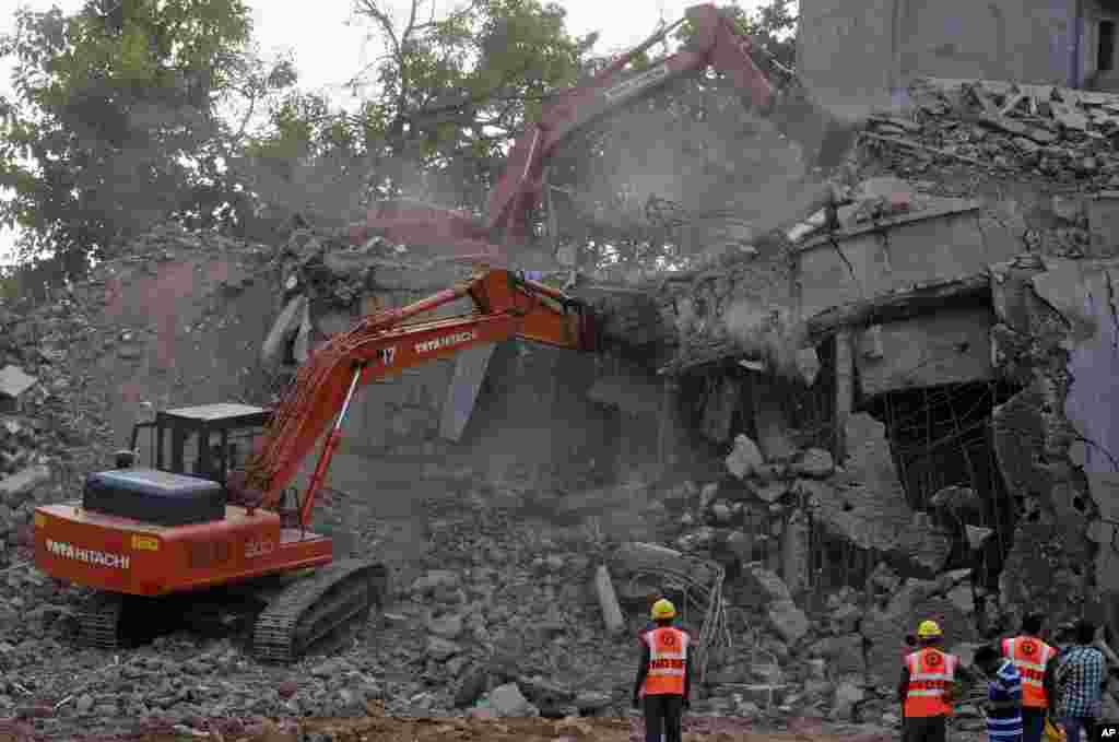 Para anggota Pasukan Penanggulangan Bencana Nasional India (NDRF) India's National Disaster Response Force (NDRF) mengawasi pembersihan puing-puing dari reruntuhan gedung yang ambruk di Canacona, India (5/1). (AP/Rafiq Maqbool)