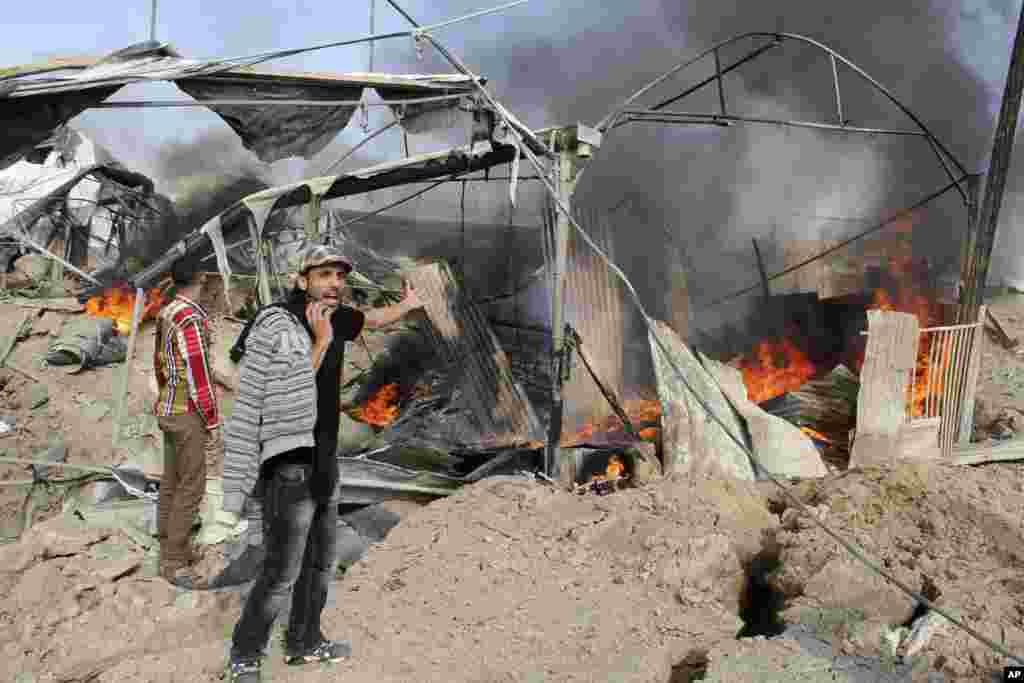 A Palestinian man reacts as flames and smoke rise from a smuggling tunnel after an Israeli strike along the border between Egypt and Rafah in the southern Gaza Strip, November 21, 2012.