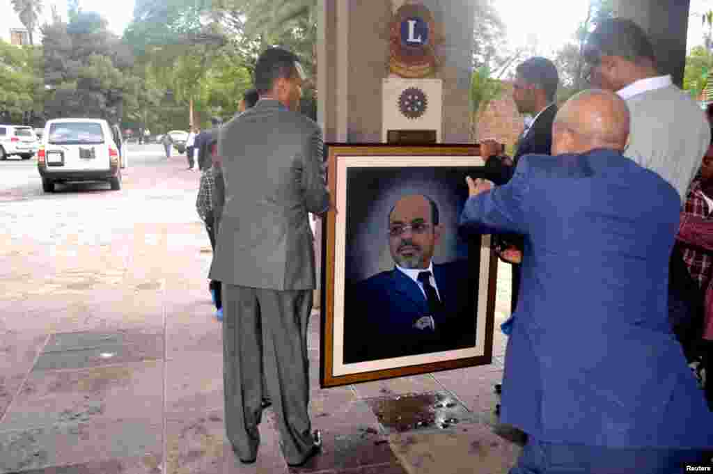 Officials move a portrait of Meles shortly after the announcement of his death in Addis Ababa, August 21, 2012.