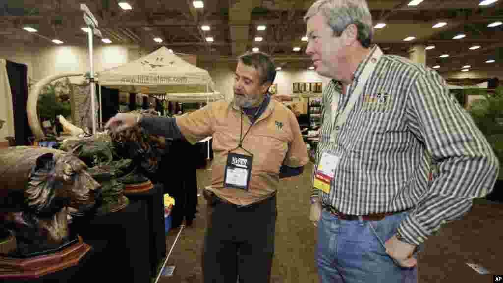 Hunters buy special permits from some African governments to hunt large wildlife on a restricted basis. Fees sometimes help fund animal conservation progrems. When the Dallas Safari Club auctioned a permit to hunt an endangered black rhino, the FBI investigated death threat claims. The club's executive director, Ben Carter, (right), was photographed with a wildlife artist at the club's January, 2014 show.