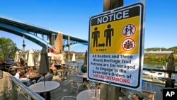 Patrons enjoy their takeout on the deck at Redfin Blues restaurant, overlooking the Allegheny River, May 13, 2020 in Pittsburgh.