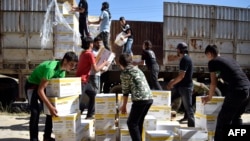 Para petugas Program Pangan Dunia PBB (WFP) dan Bulan Sabit Merah Arab Suriah mendistribusikan bantuan pangan bagi warga di kota Al-Houla yang dikuasai pemberontak, di pinggiran utara provinsi Homs, Suriah (foto: dok). 