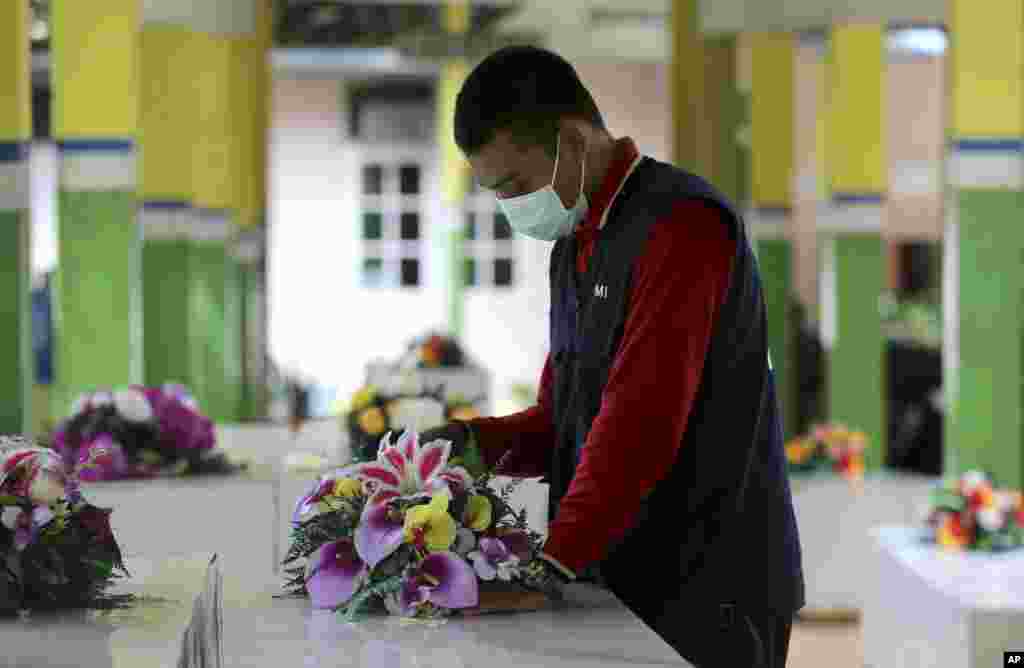 Seorang anggota Palang Merah Indonesia mempersiapkan peti mati untuk korban bencana AirAsia Penerbangan QZ8501 di rumah sakit pusat di Pangkalan Bun. Sejumlah kapal telah tiba hari Jumat dengan peralatan canggih untuk mendeteksi posisi bangkai pesawat dan lebih dari 145 orang yang masih hilang sejak pesawat itu jatuh ke laut lima hari yang lalu. 