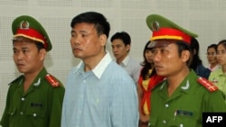 Blogger Truong Duy Nhat (tengah) saat menghadiri sidang di pengadilan kota Da Nang, Vietnam (4/3).