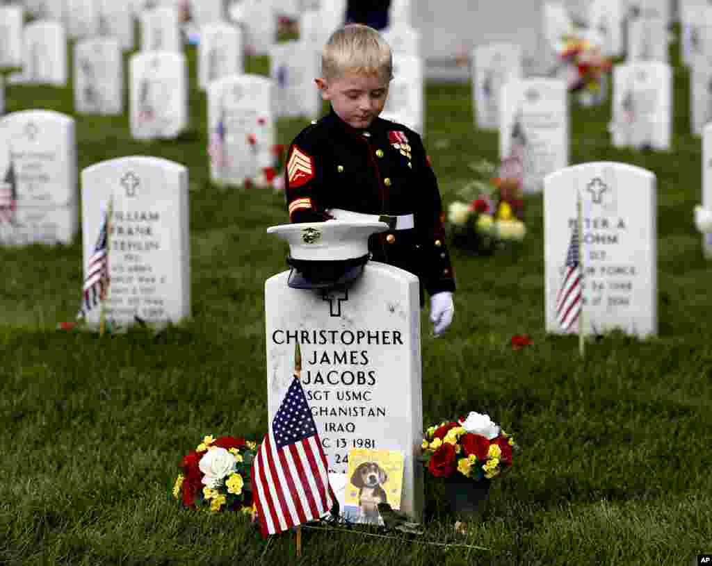 Christian Jacobs, 5, of Hertford, N.C., dressed as a Marine, pauses at his father's gravestone on Memorial Day at Arlington National Cemetery in Arlington, Virginia. Christian's father Marine Sgt. Christopher James Jacobs died in a training accident in 2011.