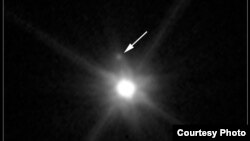 A newly discovered moon is seen orbiting the dwarf planet Makemake. (Hubblesite.org)