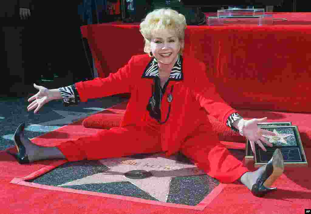 La actriz Debbie Reynolds posa junto a su segunda estrella en el Camino de la Fama en Hollywood, 1997. 