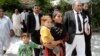 FILE - Khalida Bibi, center, sister of Farzana Iqbal, walks with her lawyer as she arrives at a court in Lahore for the trial of those implicated in Iqbal's death, June 2, 2014.