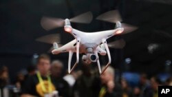 FILE - In this Jan. 5, 2017 file photo, an exhibitor demonstrates a drone flight at CES International, in Las Vegas. President Donald Trump signed a memorandum permitting states, localities and tribes to craft their own pilot programs to test drones, Oct. 25, 2017.