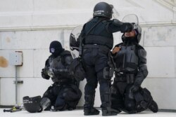 FILE - In this Jan. 6, 2021, file photo a police officer has eyes flushed with water after a confrontation with rioters at the Capitol in Washington.
