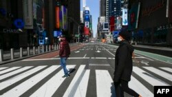 နယူးယောက်မြို့ Time Square အနီး လမ်းဖြတ်ကူးနေသော လူတချို့ (သတင်းဓာတ်ပုံ - မတ် ၂၂၊ ၂၀၂၀)