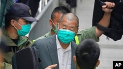 FILE - Democracy advocate Jimmy Lai, center, leaves the Hong Kong's Court of Final Appeal in Hong Kong, Feb. 9, 2021. Lai was found guilty of two counts of fraud related to a lease on Tuesday in Hong Kong.