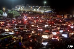 Antrean mobil yang menunggu untuk menaiki kapal feri saat masyarakat kembali ke kampung halaman di pelabuhan Merak di Cilegon, Jawa Barat, dini hari pada 6 April 2024.