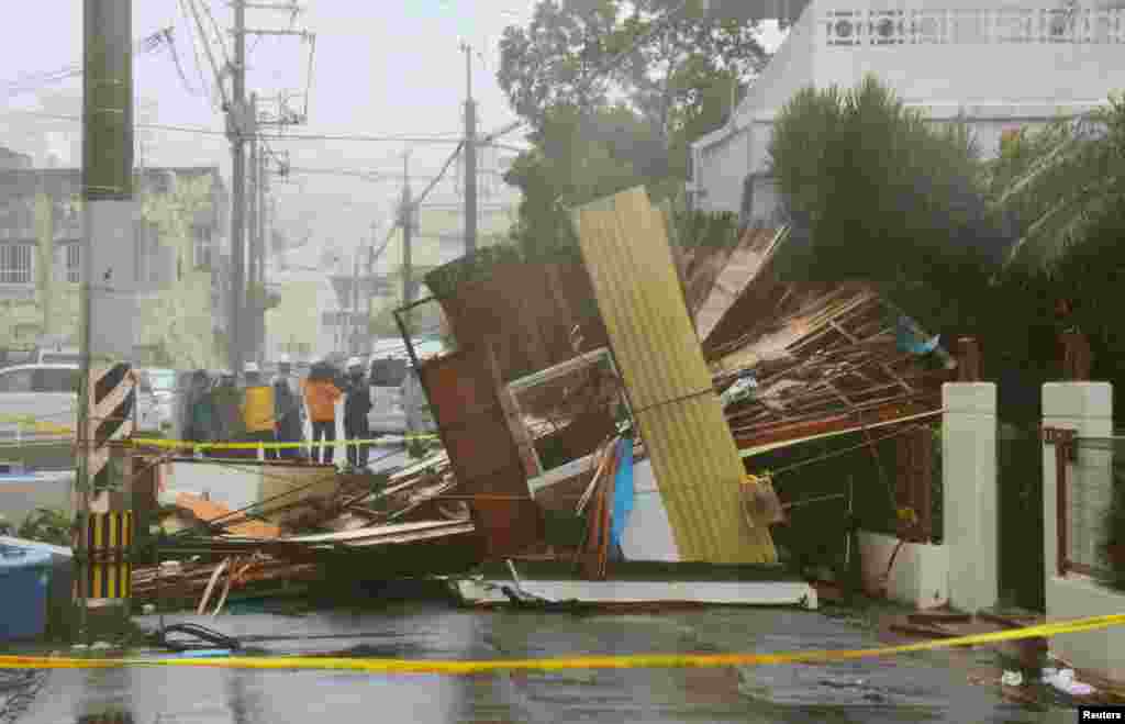 A wooden house that collapsed due to strong winds caused by Typhoon Neoguri is seen in Naha, on Japan's southern island of Okinawa, in this photo taken by Kyodo, July 8, 2014.