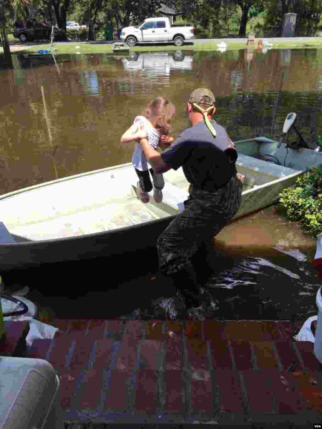Graham Kinchen of St. Amant, Louisiana, takes time off to give his daughter a boat ride — in their front yard. (D. Kinchen /VOA)