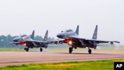 Dua jet tempur SU-30 China lepas landas dari lokasi yang tidak ditentukan untuk melakukan patroli di atas Laut China Selatan.China menerbangkan lebih dari 30 pesawat militer, termasuk jet tempur SU-30, menuju Taiwan, Sabtu, 3 Oktober 2021. (Jin Danhua/Xinhua via AP)