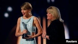 Taylor Swift accepts the Milestone Award from her mother, Andrea, at the 50th Annual Academy of Country Music Awards in Arlington, Texas, April 19, 2015. 