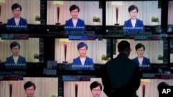 A man watches the television message that Hong Kong Chief Executive Carrie Lam makes an announcement on the extradition bill, at a home electronics retailer in Hong Kong, Sept. 4, 2019.