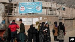 Sejumlah perempuan Afghanistan tampak berdiri di luar area Universitas Kabul di Kabul, Afghanistan, pada 21 Desember 2022. Taliban telah melarang perempuan untuk menempuh pendidikan di bangku perguruan tinggi. (Foto: AP/Ebrahim Noroozi)