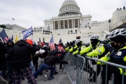 Wafuasi wa Rais Trump wakijaribu kuvuka kwa kutumia mabavu kizuizi kilichowekwa na polisi katika eneo la Bunge la Marekania mjini Washington, Jumatano Januari 06, 2021.