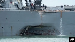 FILE - damage is visible as the guided-missile destroyer USS John S. McCain steers towards Changi naval base in Singapore following a collision with the merchant vessel Alnic MC. 
