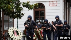 Police officers walk at the site of wreath laying ceremony after exchanges of gunfire in Vienna, Austria, Nov. 3, 2020. 