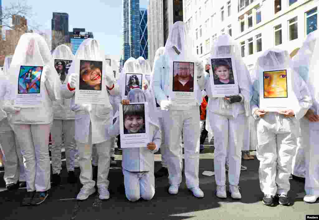 Protesters hold photos of school shooting victims during a "March For Our Lives" demonstration in New York City, 2018. (REUTERS/Shannon Stapleton )
