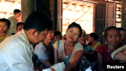 Seorang petugas kesehatan pemerintah mengambil darah dari seorang perempuan untuk diperiksa malaria di negara bagian Kayin Myanmar (28/11/2014).
