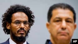 Ahmad al-Mahdi al-Faqi, left, enters the court room for his initial appearance at the International Criminal Court in The Hague, Netherlands, Sept. 30, 2015.
