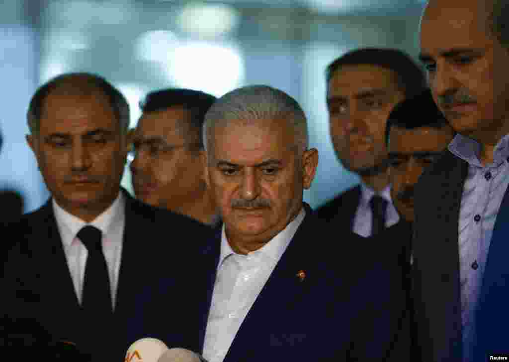 Turkey's Prime Minister Binali Yildirim, center, speaks to reporters next to Interior Miinister Efkan Ala, left, at the Ataturk airport in Istanbul, Turkey, following a multiple suicide bombing, June 29, 2016.