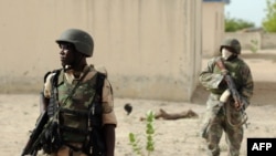 FILE - Nigerian soldiers are seen on patrol near a Boko Haram camp in the north of Borno state.