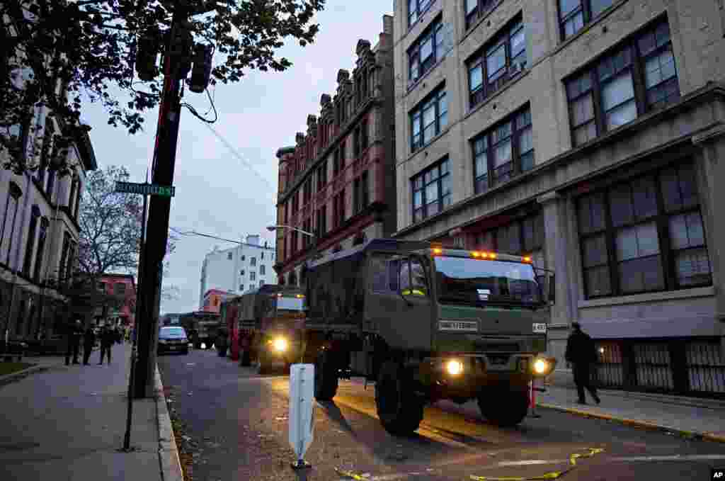 Members of the National Guard stand ready with large trucks used to pluck people from high water in Hoboken, N.J. , Oct. 31, 2012 in the wake of superstorm Sandy.