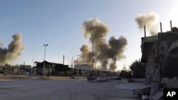 This photo released by the Syrian Civil Defense White Helmets, which has been authenticated based on its contents and other AP reporting, shows smoke rising after Syrian government airstrikes hit in the town of Douma, in the eastern Ghouta region east of Damascus, Syria, April. 7, 2018. 