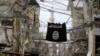 FILE - An Islamic State flag hangs amid electric wires over a street in Ain al-Hilweh Palestinian refugee camp, near the port-city of Sidon, southern Lebanon Jan. 19, 2016.