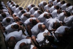FILE - MS-13 gang members wait to be escorted upon arrival at the maximum-security jail in Zacatecoluca, El Salvador, Aug. 9, 2017.
