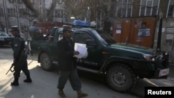 Afghan policemen stand guard at site where US advisor was killed by Afghan policewoman in Kabul, December 24, 2012