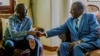 FILE: Zimbabwe's President Emmerson Mnangagwa (R) shakes hands with the leader of the Movement for Democratic Change (MDC), the country's main opposition party, Morgan Tsvangirai (L), who has been battling cancer, during a visit at his home in Harare on January 5, 2018. The visit came as Zimbabwe's political parties prepare to begin campaigning for elections due later this year -- the first since former president stood down following a brief military takeover. / AFP PHOTO / Jekesai NJIKIZANA