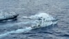 Kapal penjaga pantai China, bawah, menggunakan meriam air sementara di dekatnya, kapal patroli penjaga pantai Filipina, BRP Cabra, saat kedua kapal mendekati Second Thomas Shoal di Laut Cina Selatan yang disengketakan pada 10 Desember 2023 lalu (foto: ilustrasi).