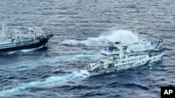 菲律賓海岸警衛隊發布照片顯示，中國海警船向菲律賓海岸巡邏艇發射水砲。（2023年12月10日）