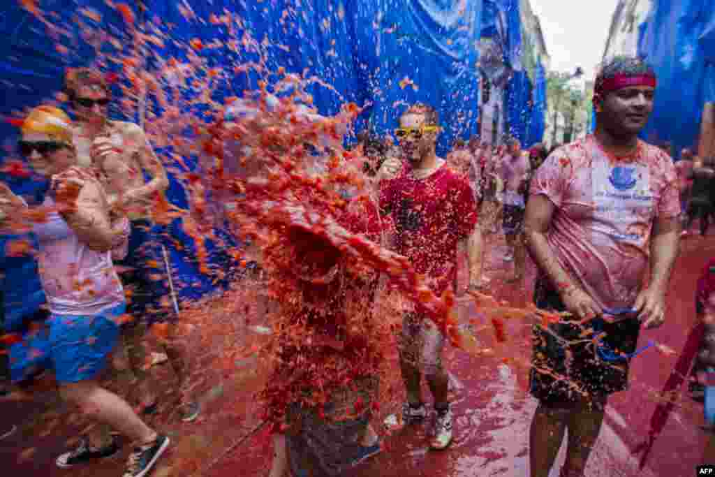 Revelers take part in the annual "Tomatina" festivities in Bunol, near Valencia, Spain. Twenty thousand revelers hurled 130 tons of squashed tomatoes at each other, drenching the streets in red in a gigantic Spanish food fight.