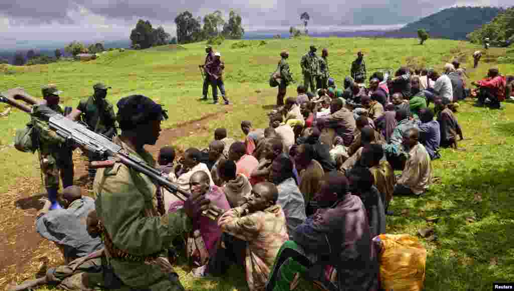 Tentara Kongo menjaga para tersangka anggota pemberontak M23 yang menyerah di kota Rutshuru, dekat Goma.