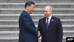 Chinese President Xi Jinping and Russian President Vladimir Putin attend a welcoming ceremony in front of the Great Hall of the People in Tiananmen Square in Beijing on May 16, 2024. (Russian state agency Sputnik via AFP)