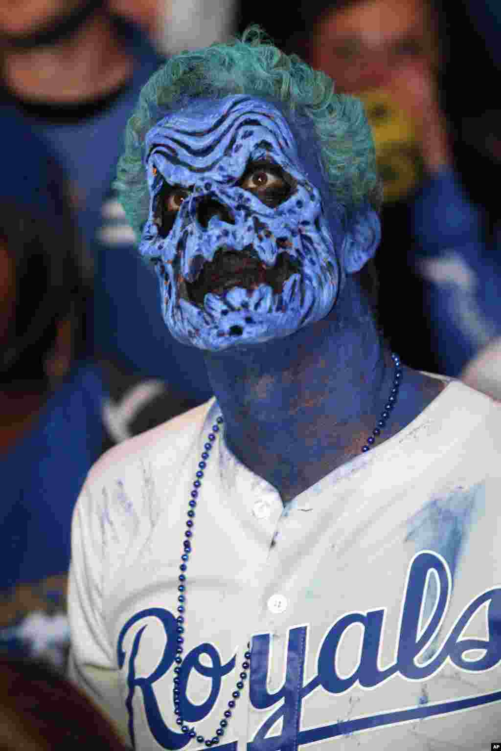 Dressed for Halloween, a Kansas City Royals fan watches Game 7 of the World Series in the Power and Light entertainment district in Kansas City, Missouri, Oct. 29, 2014.