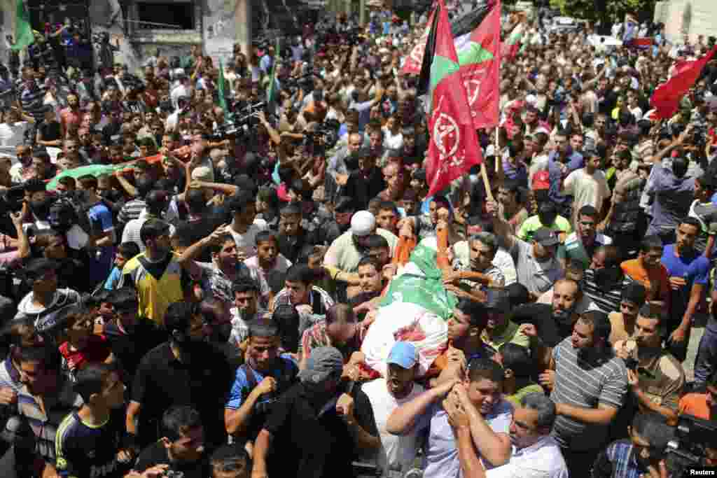 A crowd of Palestinians march during the funeral of the wife of Hamas's military leader, Mohammed Deif, his infant son Ali and other Palestinians whom medics said were killed in Israeli air strikes, in the northern Gaza Strip, Aug. 20, 2014.
