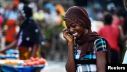 Une femme parle au téléphone sur un marché dans le quartier d'Abobo à Abidjan, en Côte d'Ivoire, le 17 avril 2011.