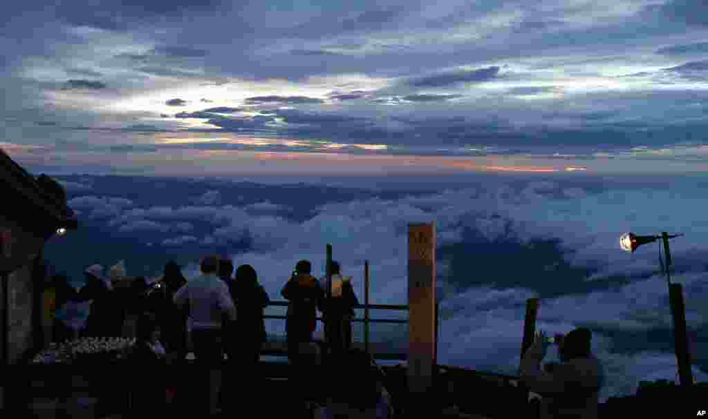 Climbers view the sunrise in early morning on Mount Fuji in Fujiyoshida city, Yamanashi prefecture, Japan.