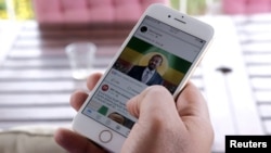 A man scrolls down his cell phone for social media newsfeed about Ethiopian Prime Minister Abiy Ahmed winning the Nobel Peace Prize in Addis Ababa, Ethiopia, Oct. 11, 2019.