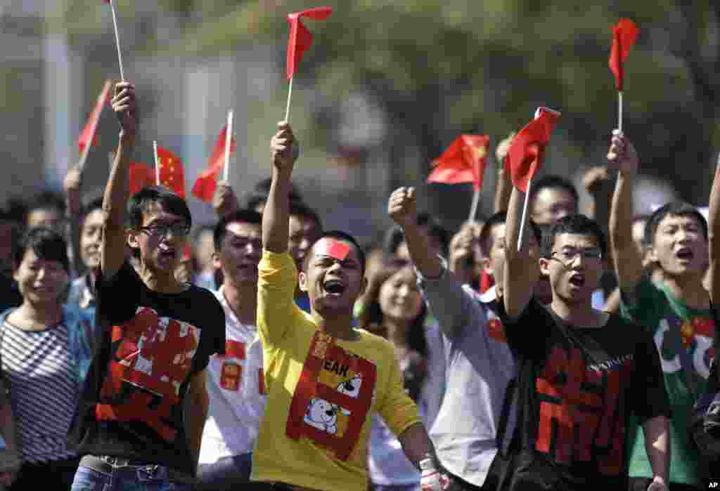Chinese protesters with the words "Boycott Japanese goods" on their shirts march towards the Japanese Embassy in Beijing, China, September 16, 2012.