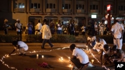 Des passants allument des bougies après l'attentat dans un hôtel à Ouagadougou, au Burkina Faso, le 23 janvier 2016.