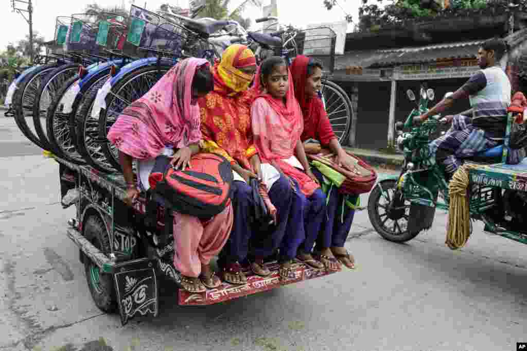 Women ride on an improvised motorbike carrying the bicycles they received from their school in Malancha, India.